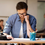 focused man concentrates on the writing project at his desk