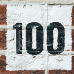 "100" painted on a brick wall